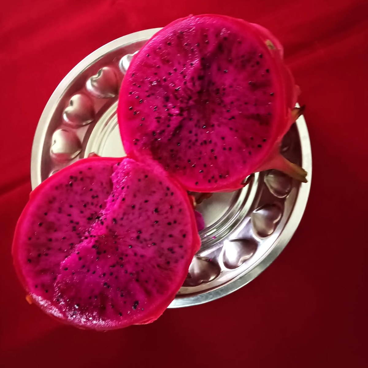 Pink dragon fruit cut in half showing deep pink flesh